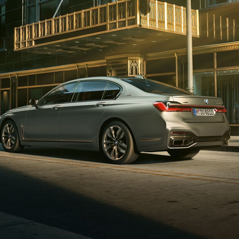 BMW M760Li xDrive Sedan with V12 engine BMW M760Li xDrive Sedan, lateral rear view in front of skyscrapers in urban setting