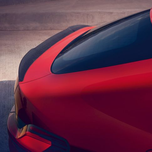 BMW X4 M, M rear spoiler in carbon. BMW X4 M in Toronto Red metallic, exterior, M Carbon exterior package, detailed rear view with M rear spoiler in carbon.
