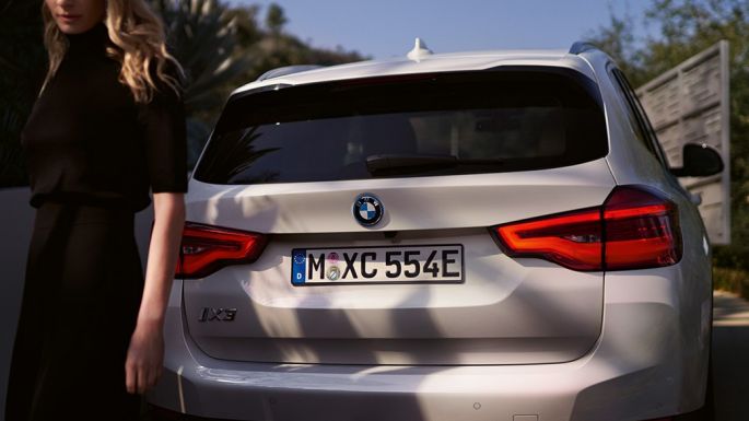 Rear with BMW i specific diffuser BMW iX3 G08 rear view with woman Rear with BMW i specific diffuser BMW iX3 G08 2020 Mineral White metallic rear view with woman