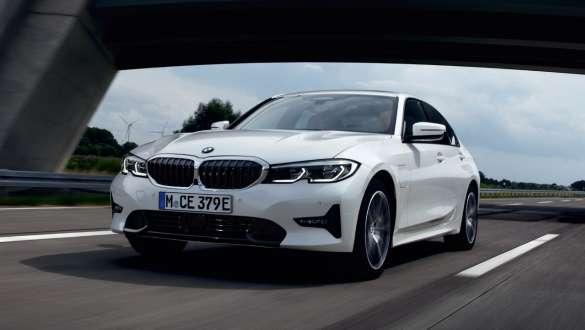 มุมมองด้านหน้าแบบ 3/4 ของ BMW ซีรีส์ 3 Sedan G20 ระบบปลั๊กอินไฮบริดรุ่นปี 2021 ขณะขับขี่ มุมมองด้านหน้าแบบ 3/4 ของ BMW ซีรีส์ 3 Sedan G20 ระบบปลั๊กอินไฮบริดรุ่นปี 2021 ขณะขับขี่บนท้องถนน