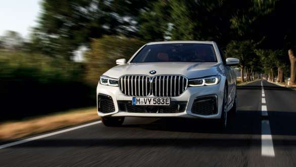 BMW 745e Sedan plug-in hybrid G11 G12 Mineral White front view BMW 745e Sedan plug-in hybrid G11 G12 Mineral White front view driving on country road