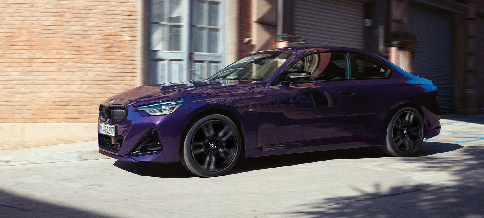 ภาพด้านข้างมุมมองสามส่วนสี่ของ BMW 2 Series Coupé G42 2021 สี Thundernight metallic ขณะขับขี่ในเมือง