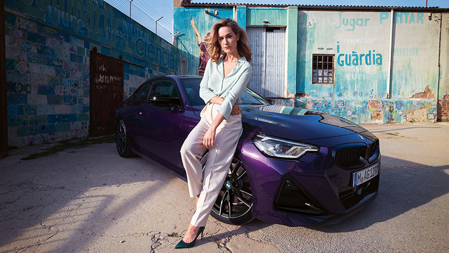 Woman leaning against BMW 2 Series Coupé G42 three-quarter front view Woman leaning against BMW 2 Series Coupé G42 three-quarter front view