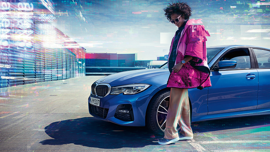 มุมมองด้านหน้าแบบ 7/8 ส่วนของ BMW ซีรีส์ 3 Sedan (G20) สี Portimao Blue Metallic มุมมองด้านหน้าแบบ 7/8 ส่วนของ BMW ซีรีส์ 3 Sedan (G20) สี Portimao Blue Metallic บนลานจอดพร้อมนายแบบอยู่เบื้องหน้า