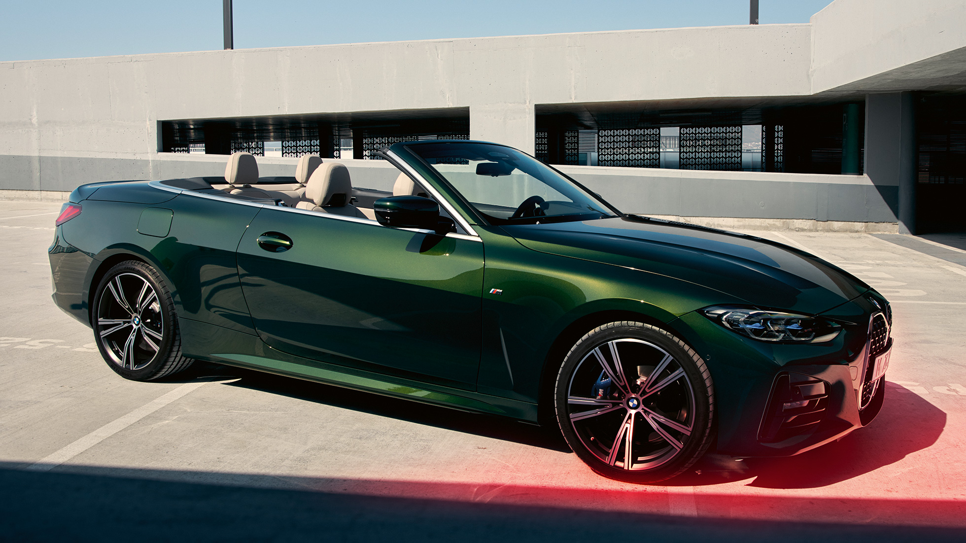 Three-quarter front view BMW 4 Series Convertible G23 2020 with a man BMW 4 Series Convertible G23 Sanremo Green metallic 2020 three-quarter front view with a man next to it