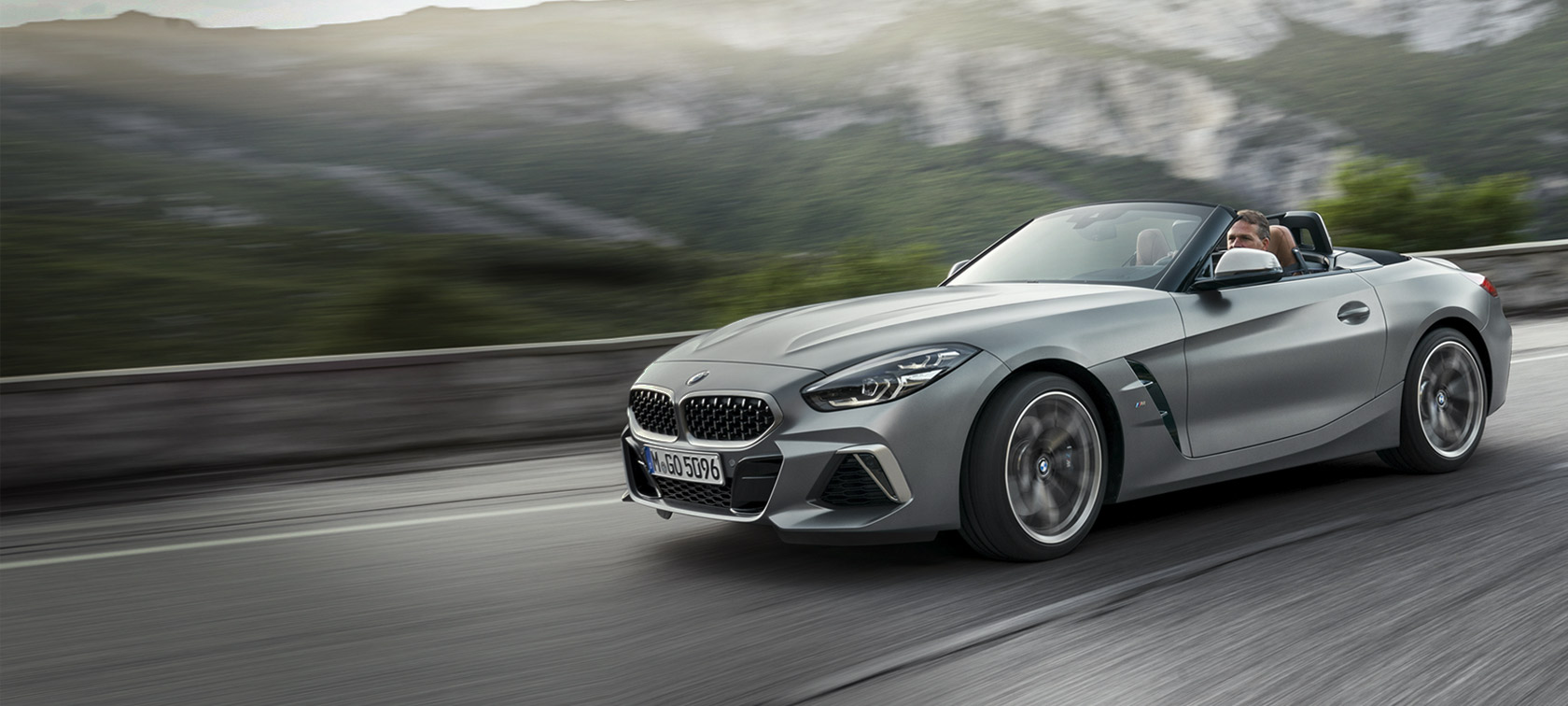 มุมมองด้านหน้าแบบสามในสี่ส่วนของ BMW Z4 M40i Roadster G29 2019 สี BMW Individual Frozen grey metallic ขณะขับขี่โดยมีฉากหลังเป็นภูเขา