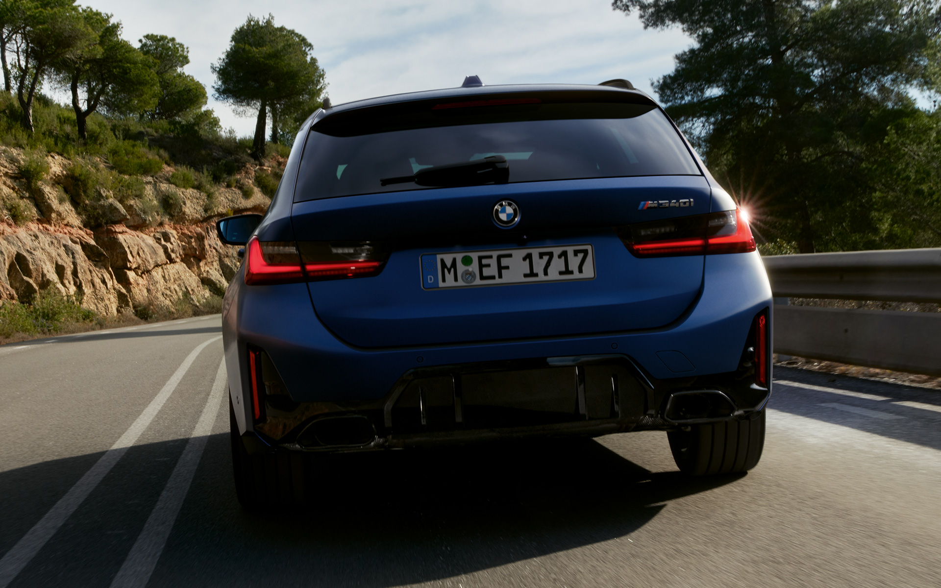 BMW M340i xDrive Touring G21 มุมมองด้านหลังขณะขับขี่บนถนน BMW M340i xDrive Touring G21 สี Frozen Tanzanite Blue มุมมองด้านหลังขณะขับขี่บนถนน
