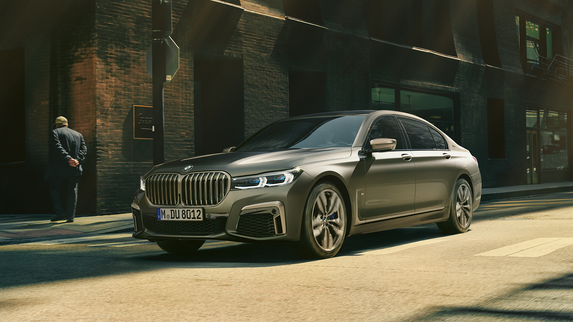 BMW M760Li xDrive Sedan in urban setting BMW M760Li xDrive Sedan, lateral front view driving on street in urban setting