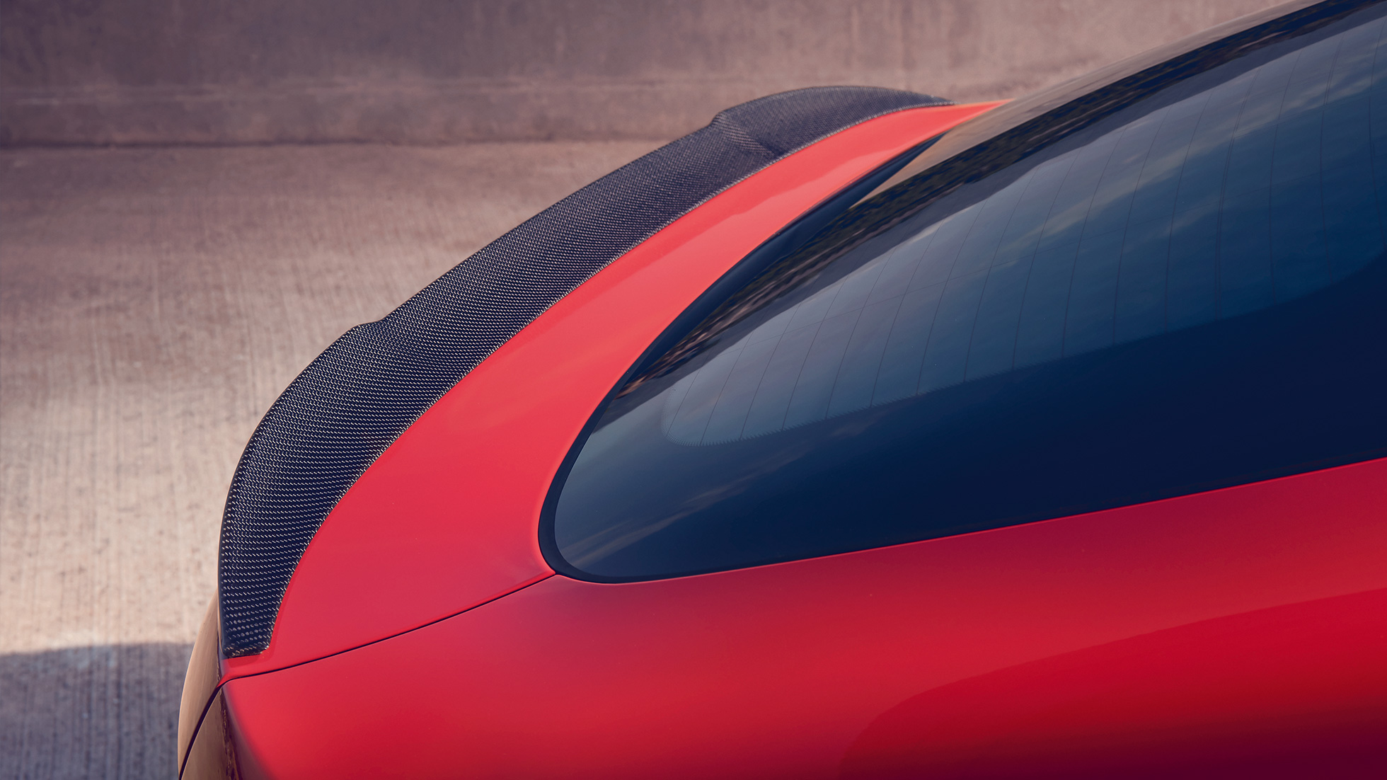 BMW X4 M, M rear spoiler in carbon. BMW X4 M in Toronto Red metallic, exterior, M Carbon exterior package, detailed rear view with M rear spoiler in carbon.