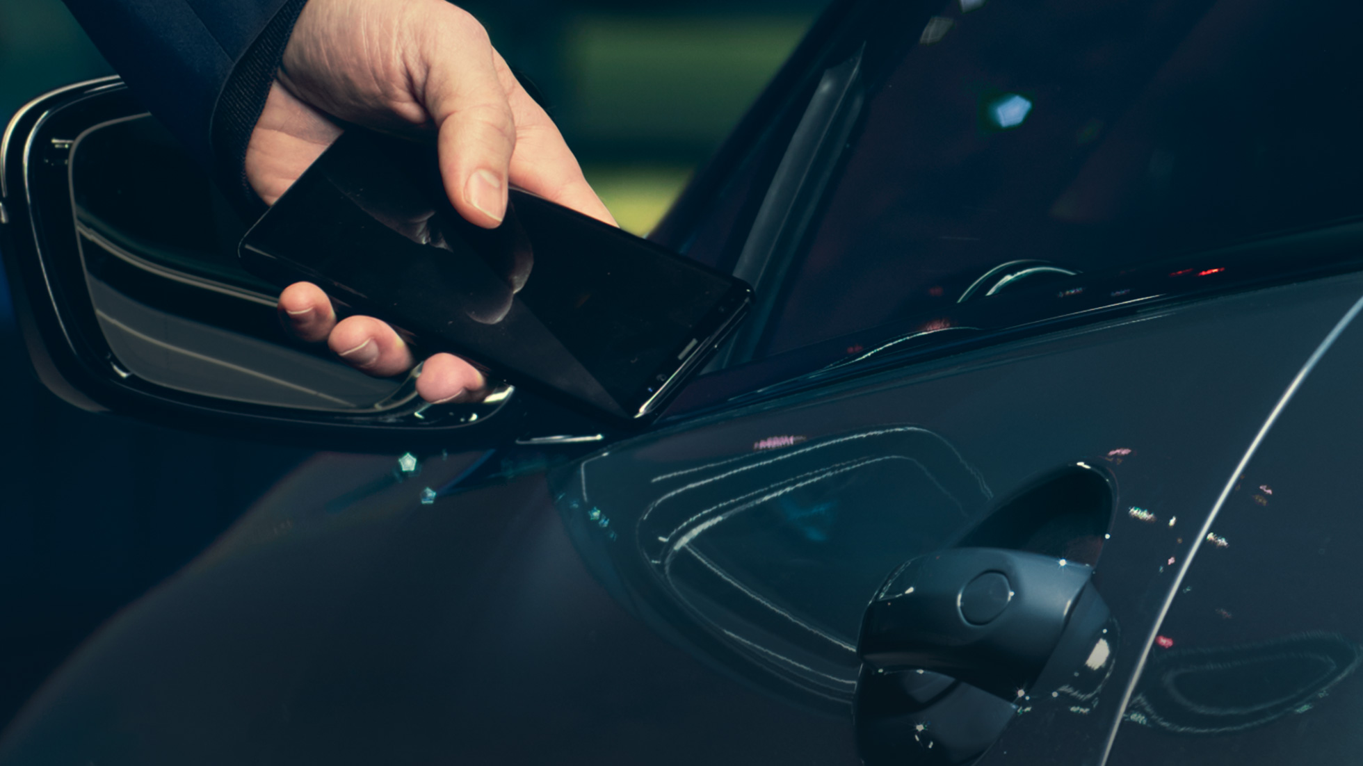 Digital Key Digital Key: Man holding his smartphone to the vehicle door from the outside