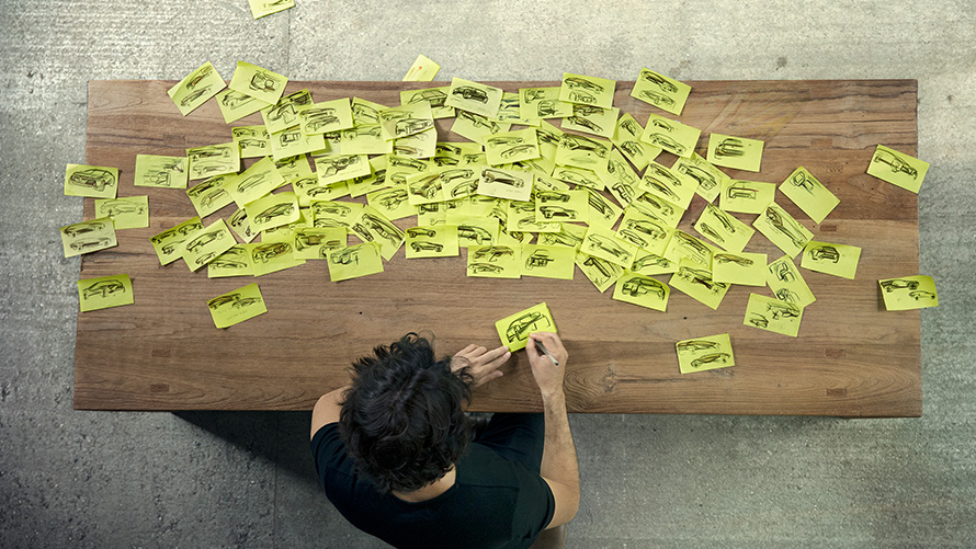 Wooden table with man and post-its from above