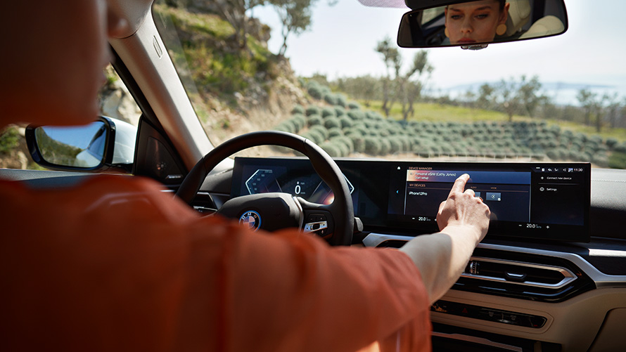 ผู้ขับขี่ BMW iX (i20) ใช้งาน BMW Curved Display ผ่านจอสัมผัส Remote Software Upgrade ผู้ขับขี่ BMW iX (i20) ใช้งาน BMW Curved Display ผ่านจอสัมผัส