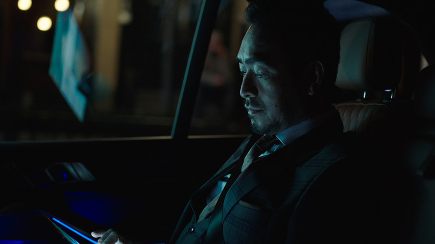 Experience Modes Man sitting in the back seat of a BMW using Experience Modes on his smartphone