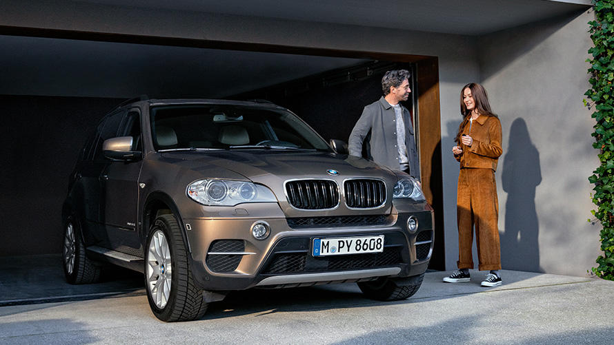 BMW standing in front of garage with models BMW Value Service BMW standing in front of garage with models