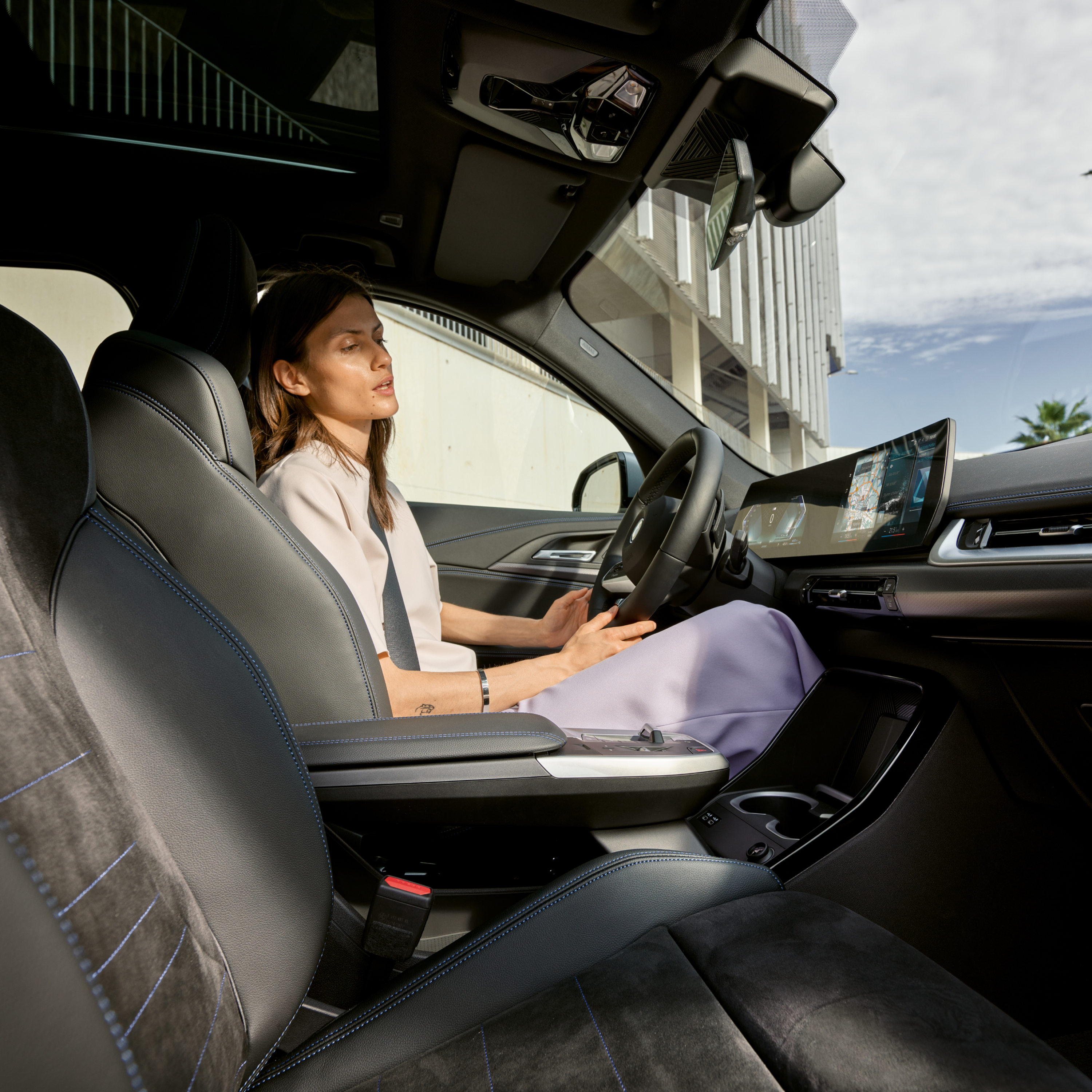 คนกำลังมองจอแสดงการควบคุมภายในรถยนต์ BMW